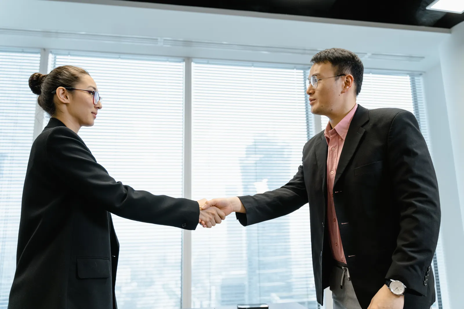 Dos profesionales formalizando un acuerdo de trabajo