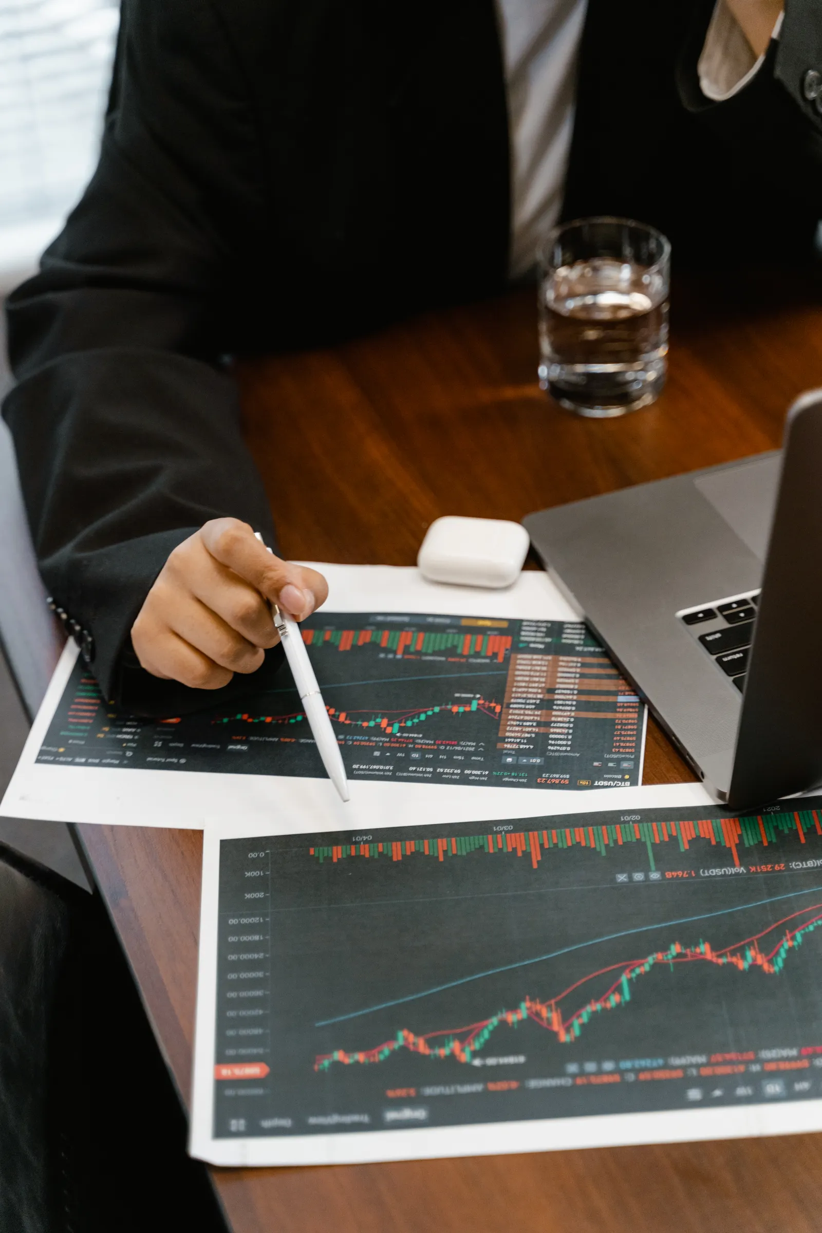 Profesional revisando reportes financieros impresos junto a una computadora